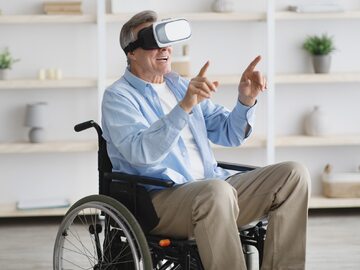 Mężczyzna na wózku wykorzystujący wirtualną rzeczywistość, zdjęcie ilustracyjne