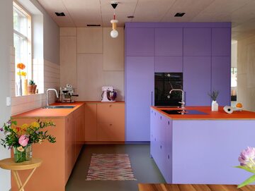 Minimalistyczna kuchnia w żywych kolorach – fioletowy i pomarańczowy to modne w 2024 roku zestawienie barw w aranżacji wnętrz