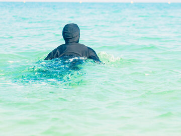 Młoda kobieta pływająca w burkini, zdjęcie ilustracyjne