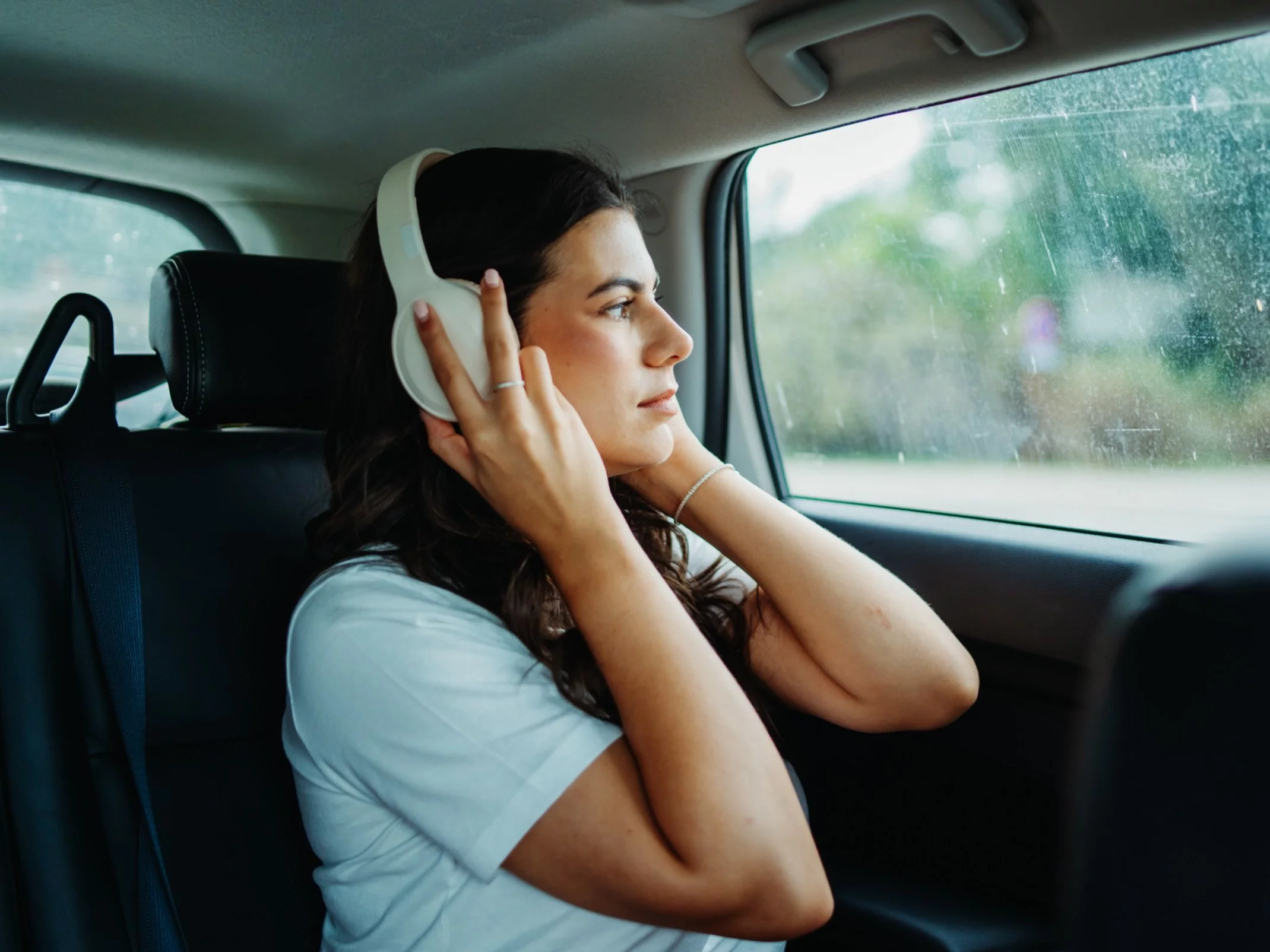 Kobieta ze słuchawkami w samochodzie, zdjęcie ilustracyjne