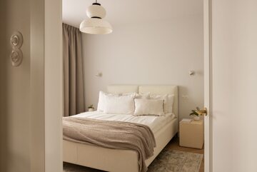 Niewielkie mieszkanie z funkcjonalną białą kuchnią i wysmakowanymi dekoracjami zaprojektowane przez Fuga Architektura Wnętrz