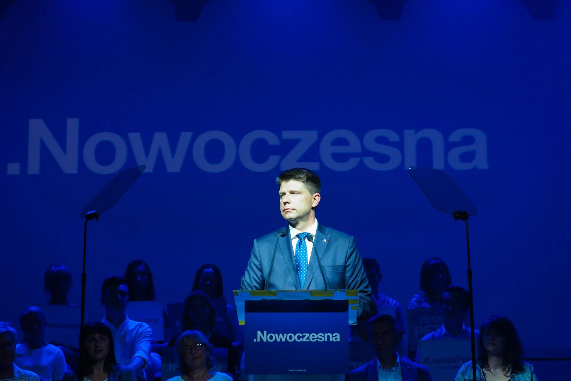 Ryszard Petru na tle logo .Nowoczesnej