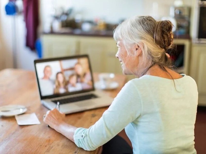 Senior rozmawiający z rodziną przez laptop