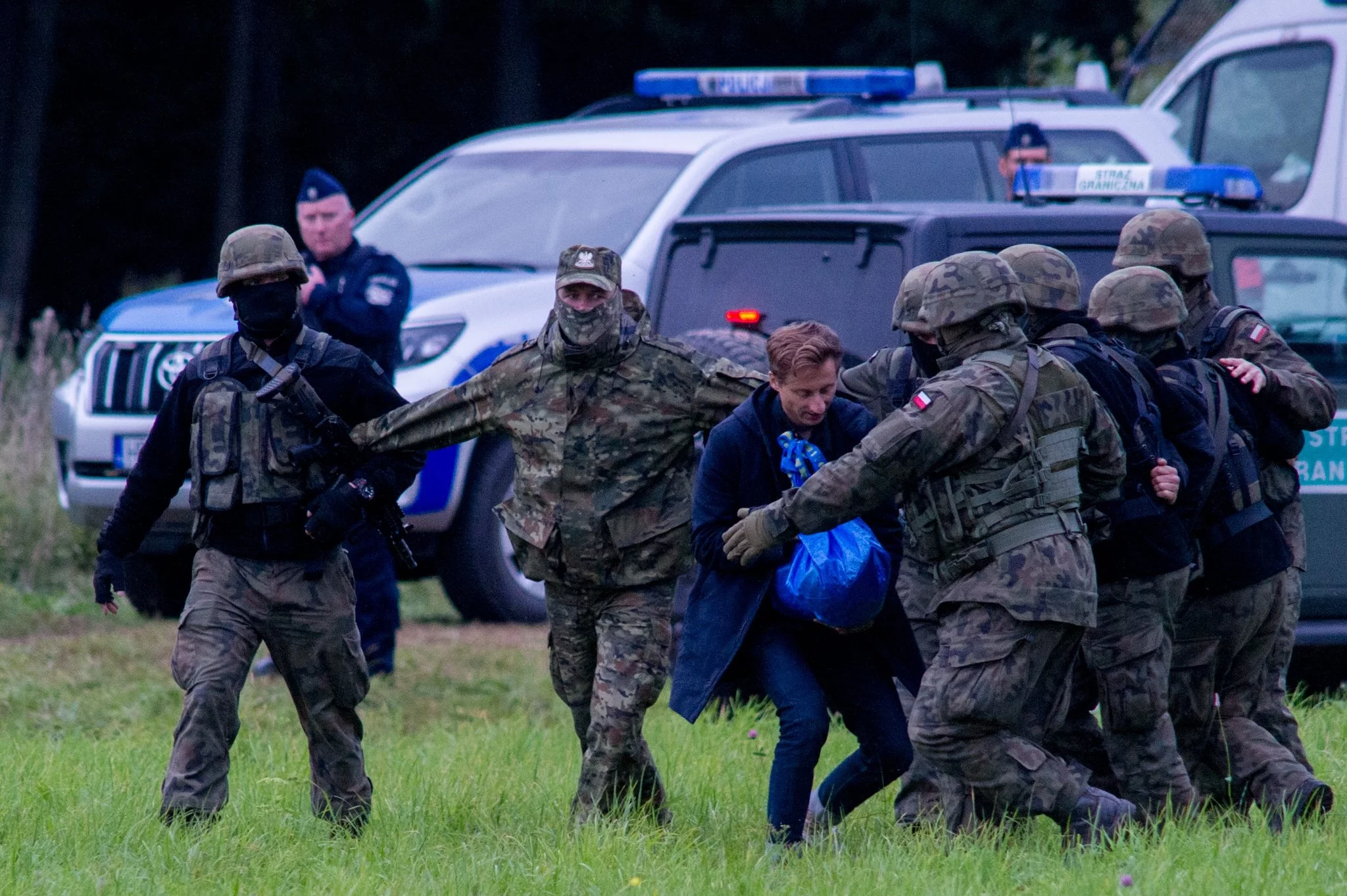 Franciszek Sterczewski biegnie z torbą z żywnością dla migrantów