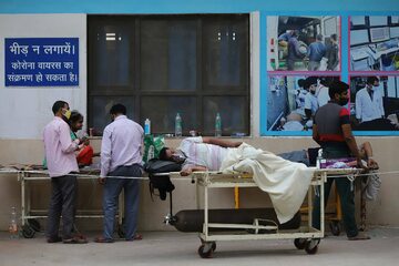 Pacjenci oczekują na wolne łóżka przed szpitalem w New Delhi