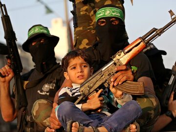 Palestyński chłopiec wśród członków Brygad al-Kassam