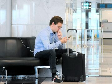 Pasażer ładuje telefon na lotnisku