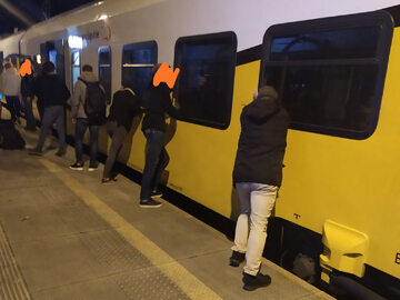 Pasażerowie przepychający pociąg Kolei Dolnośląskich