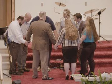 Pastor Crystal odmawia modlitwę z wiernymi