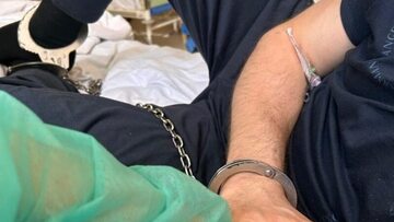 Piotr Buchalski skrępowany kajdankami na szpitalnym łóżku