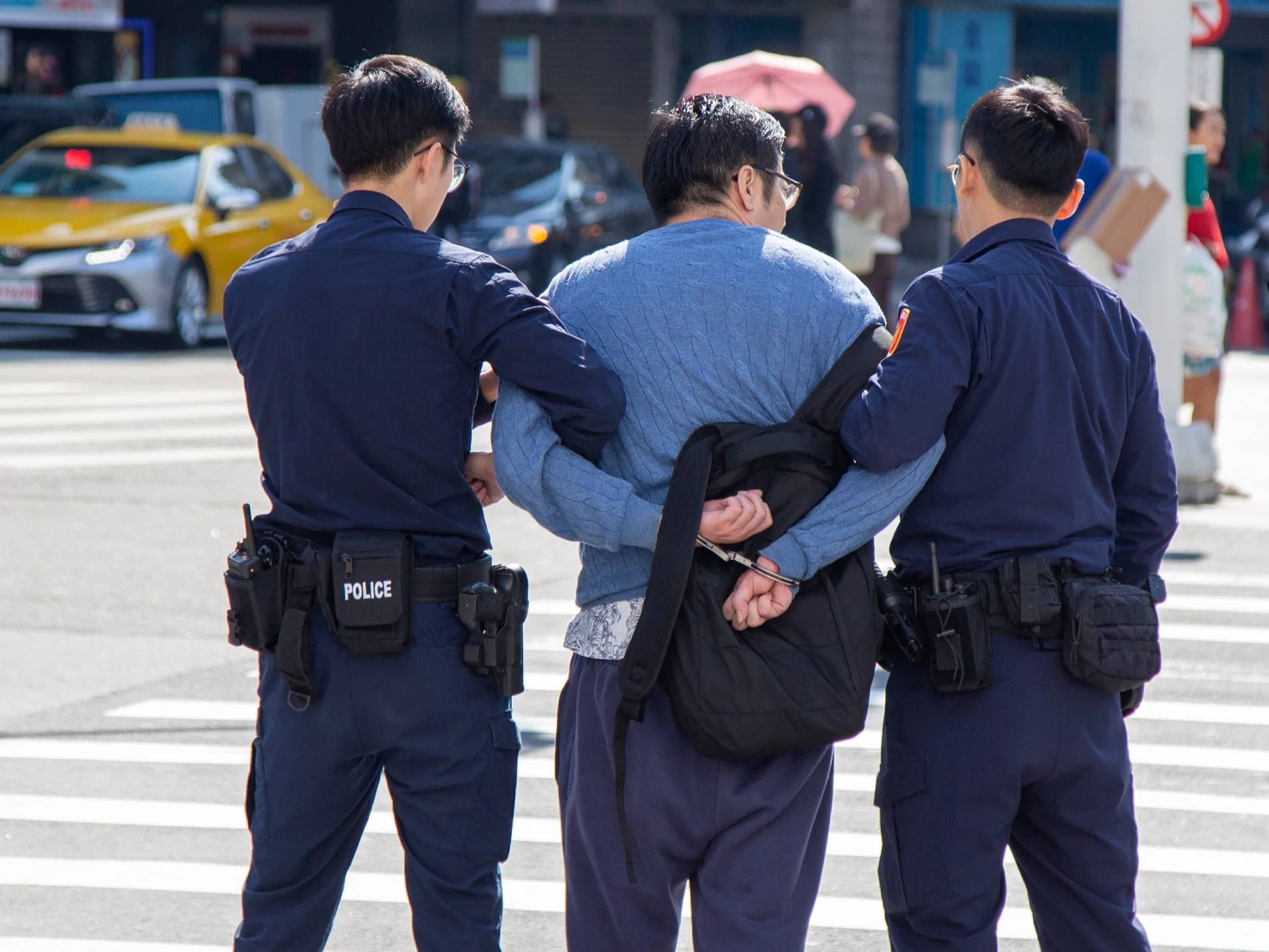 Policjanci na Tajwanie i aresztowany mężczyzna, zdjęcie ilustracyjne