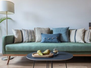 Poduszki odmienią starą sofę. Co do ich kształtu i ilości – tu panuje pełna dowolność. Na zdjęciu: sofa we wnętrzu zaprojektowanym przez Orwat Design
