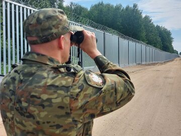 Pogranicznik przy murze oddzielającym Polskę od Białorusi