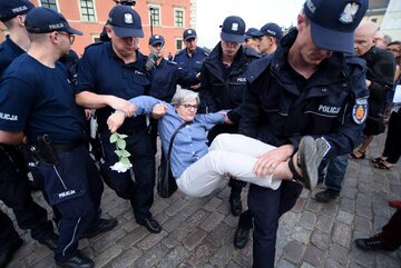Policjanci wynoszący kontrmanifestantką na miesięcznicy smoleńskiej