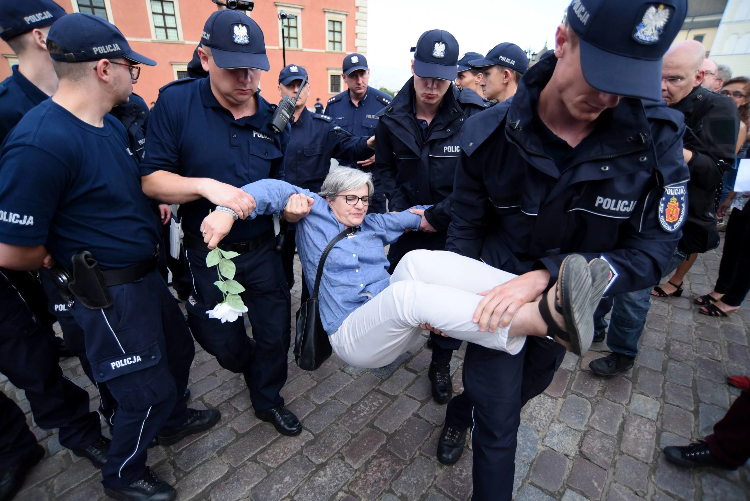 Policjanci wynoszący kontrmanifestantką na miesięcznicy smoleńskiej