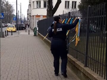 Policjantka zrywająca wstążki poparcia dla Ukrainy