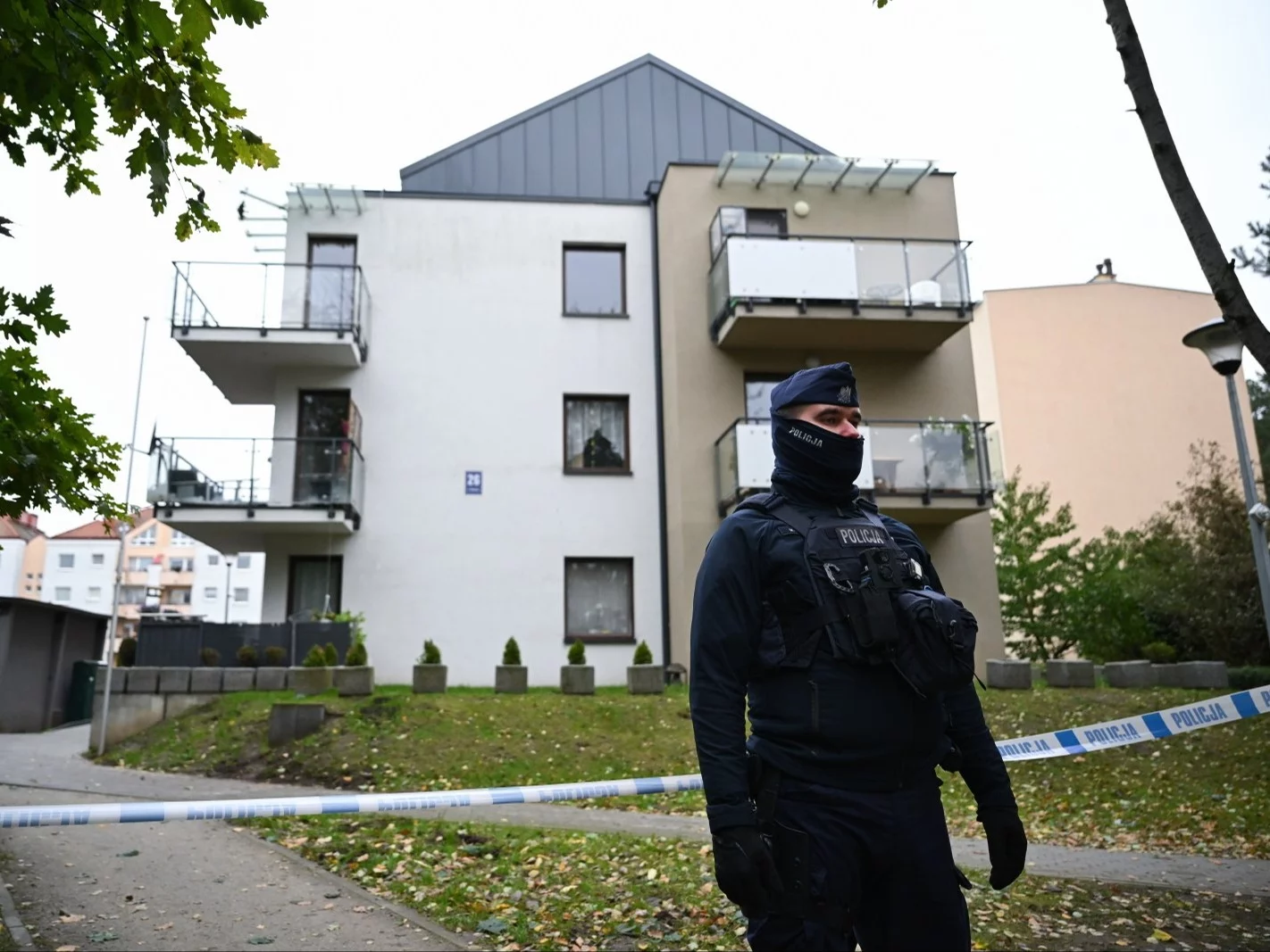 Funkcjonariusz policji przed blokiem mieszkalnym na Fikakowie w Gdyni, w którym znaleziono ciało 6-letniego dziecka