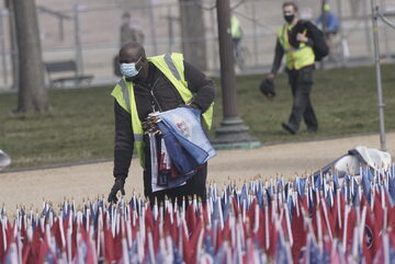 Pracownik zbierający flagi po inauguracji prezydenta Joe Bidena