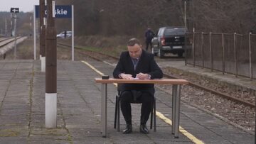 Prezydent Andrzej Duda podpisuje ustawę dot. programu Kolej Plus na peronie w miejscowości Końskie