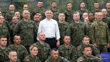 Prezydent Andrzej Duda w otoczeniu polskich żołnierzy, pełniących służbę na Łotwie.