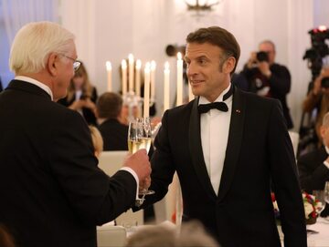 Prezydent Niemiec Frank-Walter Steinmeier wznosi toast kieliszkiem szampana z prezydentem Francji Emmanuelem Macronem, 26 maja