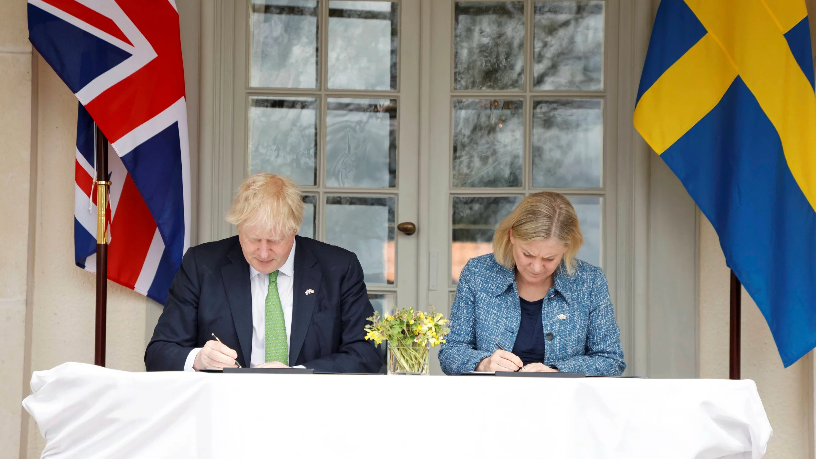 Premier Wielkiej Brytanii Boris Johnson i premier Szwecji Magdalena Andersson podpisują umowę.