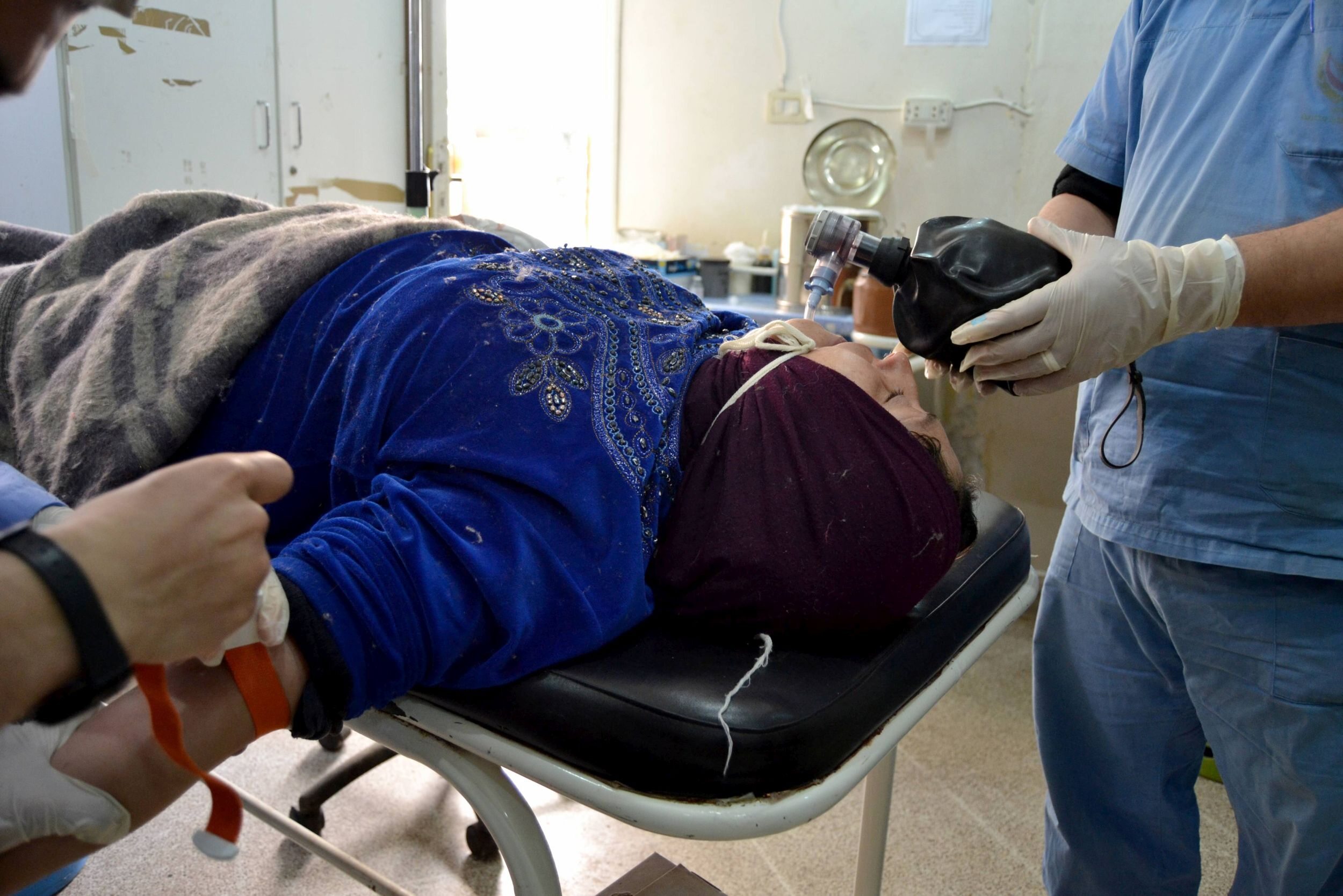 Ratownicy udzielają pomocy kobiecie, która ucierpiała wskutek ataku przy użyciu broni chemicznej