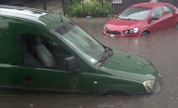 Samochody na zalanej ulewą ulicy