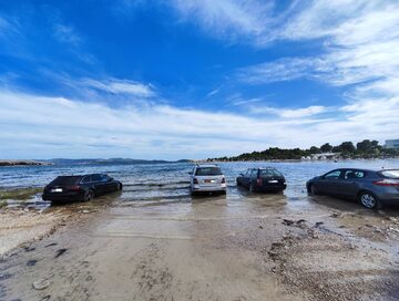 Samochody zaparkowane na plaży w Sibeniku