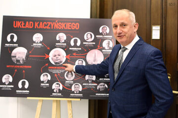 Sławomir Neumann i tablica z "Układem Kaczyńskiego"