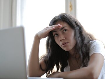 Smutna kobieta siedząca przy komputerze