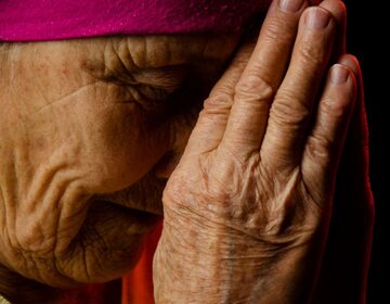 Staruszka z dłońmi złożonymi do modlitwy