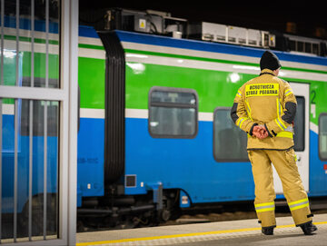 Strażak na dworcu kolejowym pomaga Ukraińcom, zdjęcie ilustracyjne