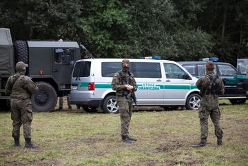 Strażnicy graniczni i żołnierze blokujący przejście migrantom na granicy polsko-białoruskiej w Usnarzu Górnym