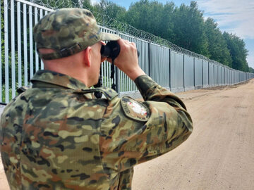 Strażnik graniczny w pobliżu zapory na granicy polsko-białoruskiej