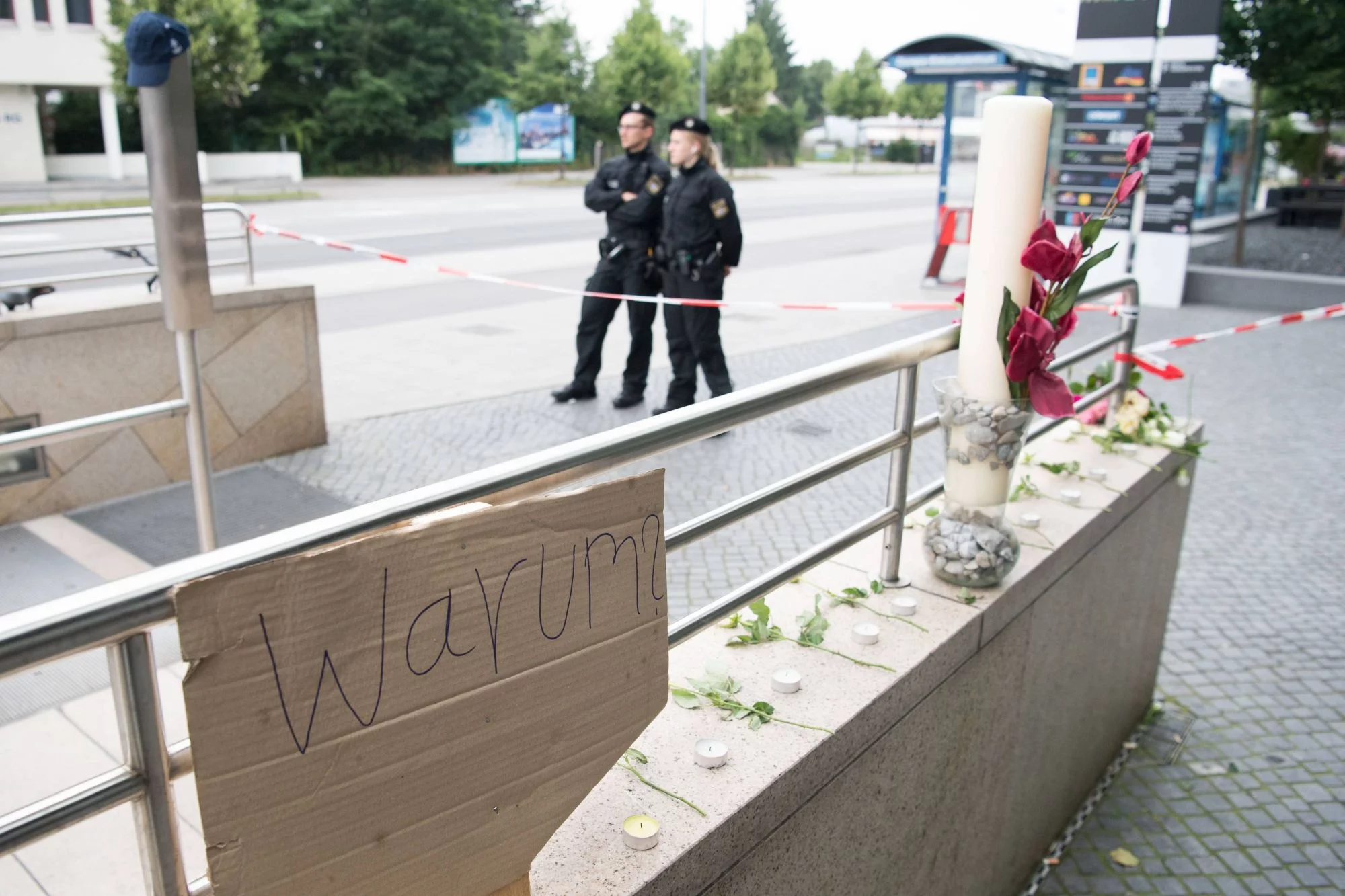 Przed centrum handlowym, w którym doszło do strzelaniny, ludzie składają kwiaty i palą znicze