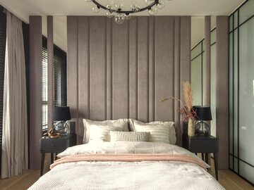 Sypialnia w beżowej kolorystyce z tapicerowanym panelem u wezgłowia. Projekt: Hola Design
