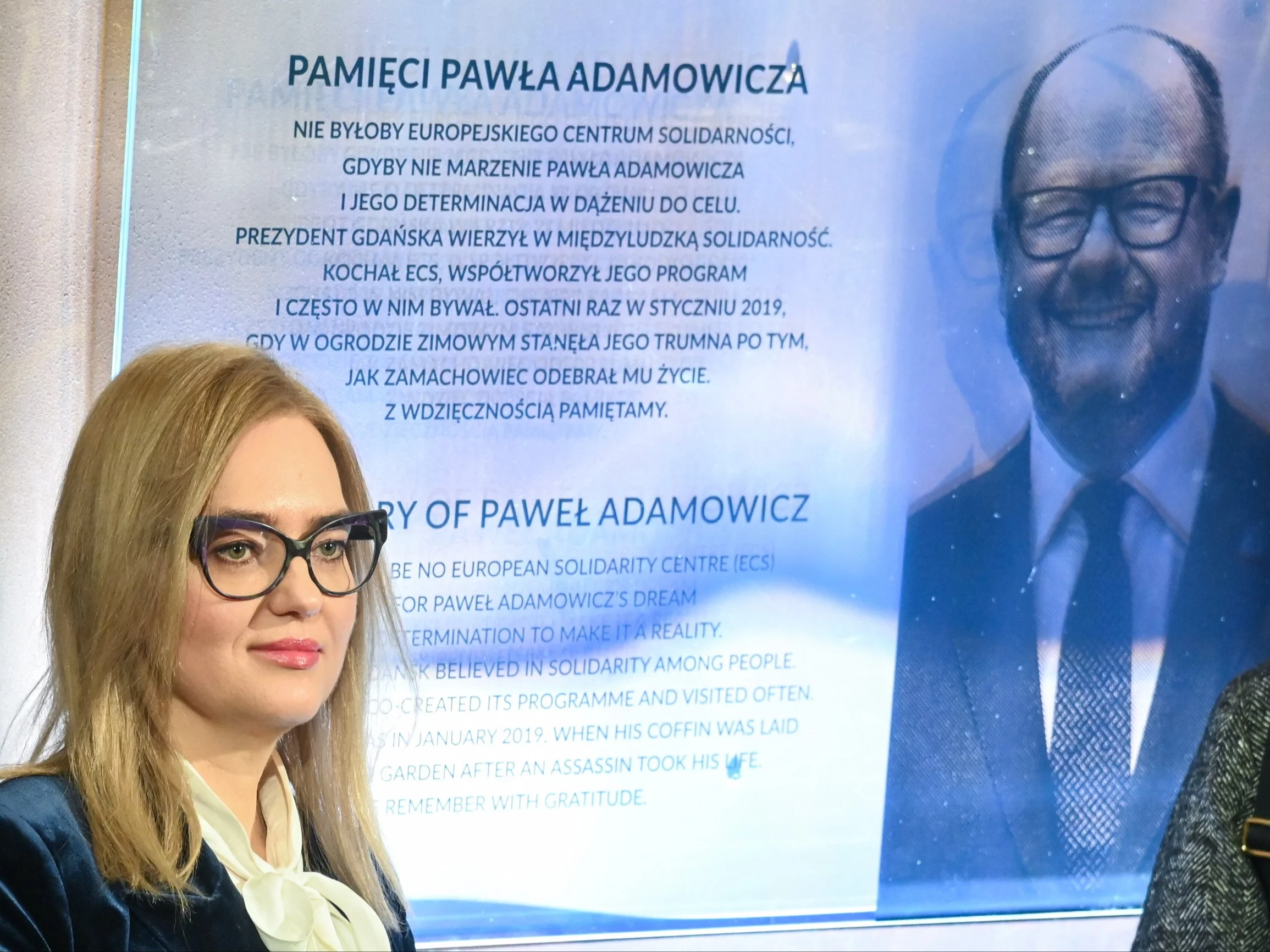 Wdowa po Pawle Adamowiczu na tle odsłoniętej tablicy pamiątkowej w ECS