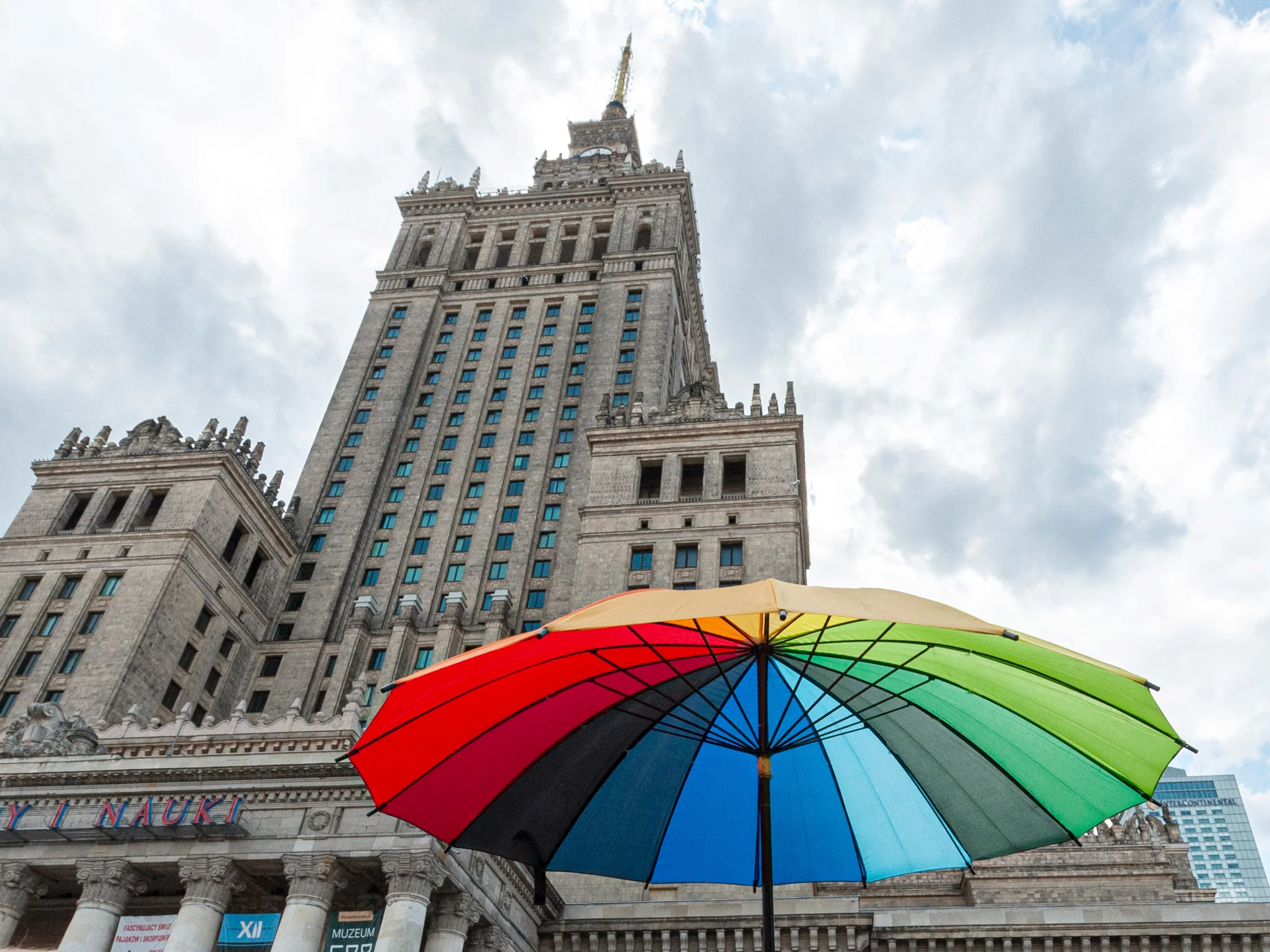 Tęczowy parasol na tle Pałacu Kultury i Nauki w Warszawie