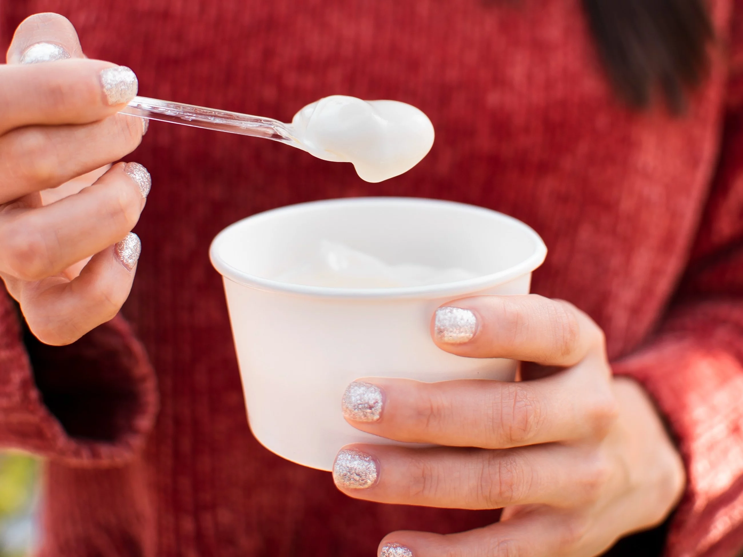 Kobieta z jogurtem w ręku, zdjęcie ilustracyjne