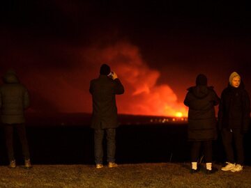 Turyści obserwujący erupcję wulkanu na Islandii