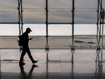 Turysta z telefonem na lotnisku/zdjęcie poglądowe