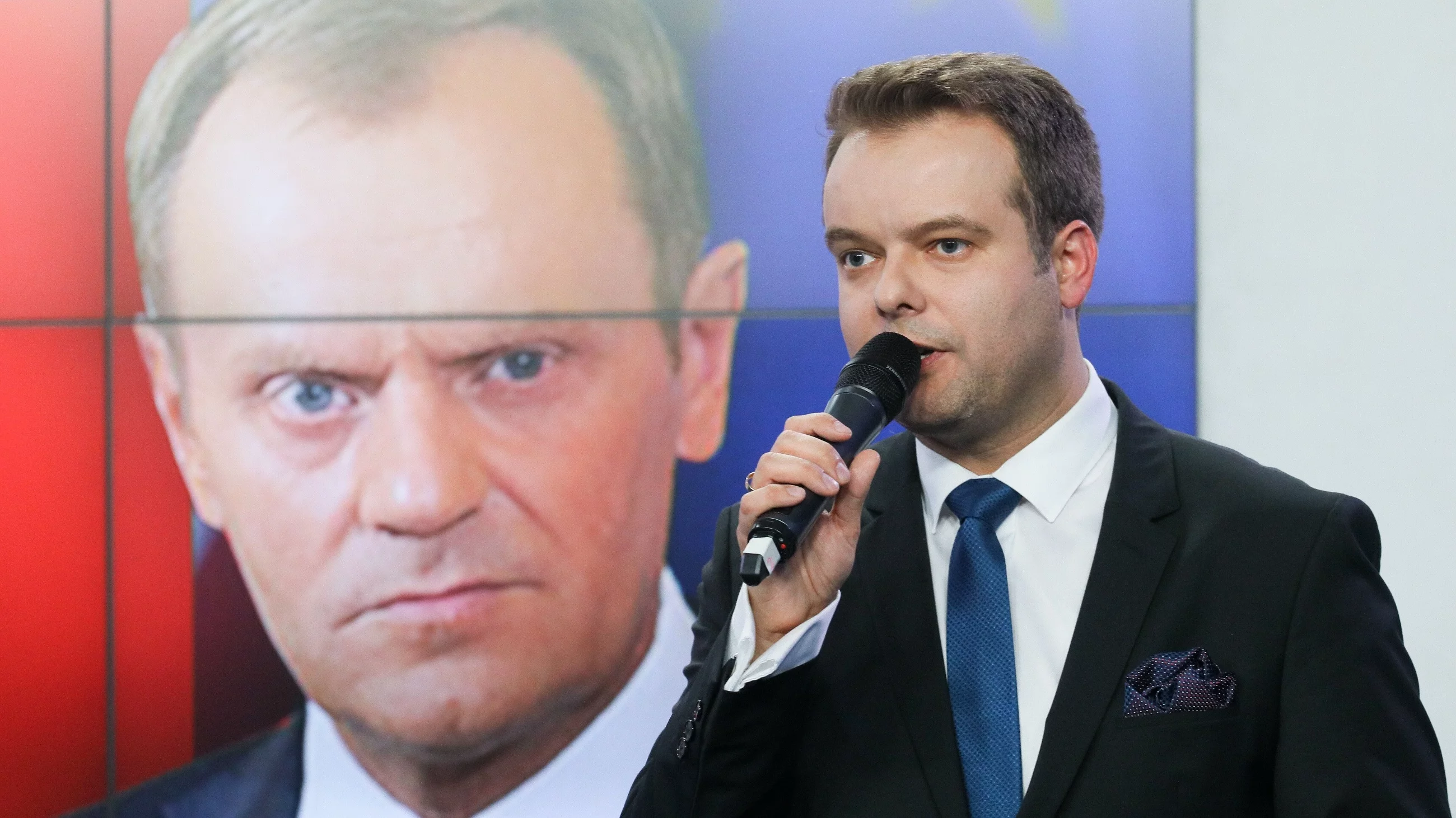 Rafał Bochenek, w tle Donald Tusk