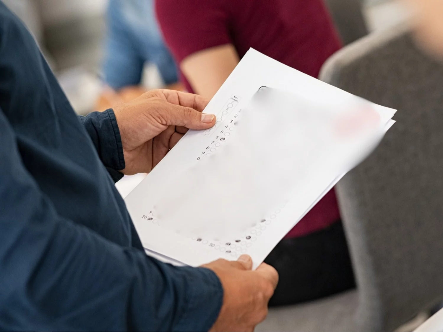 Nauczyciel trzymający w rękach sprawdzian ucznia, zdjęcie ilustracyjne