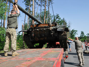 Ukraińscy żołnierze ładują rozbity rosyjski czołg na holownik, zdjęcie ilustracyjne