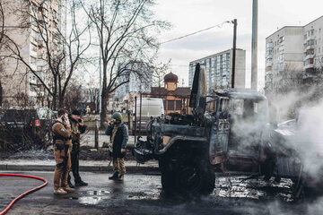 Ukraińscy żołnierze obok spalonego pojazdu po walkach w Kijowie