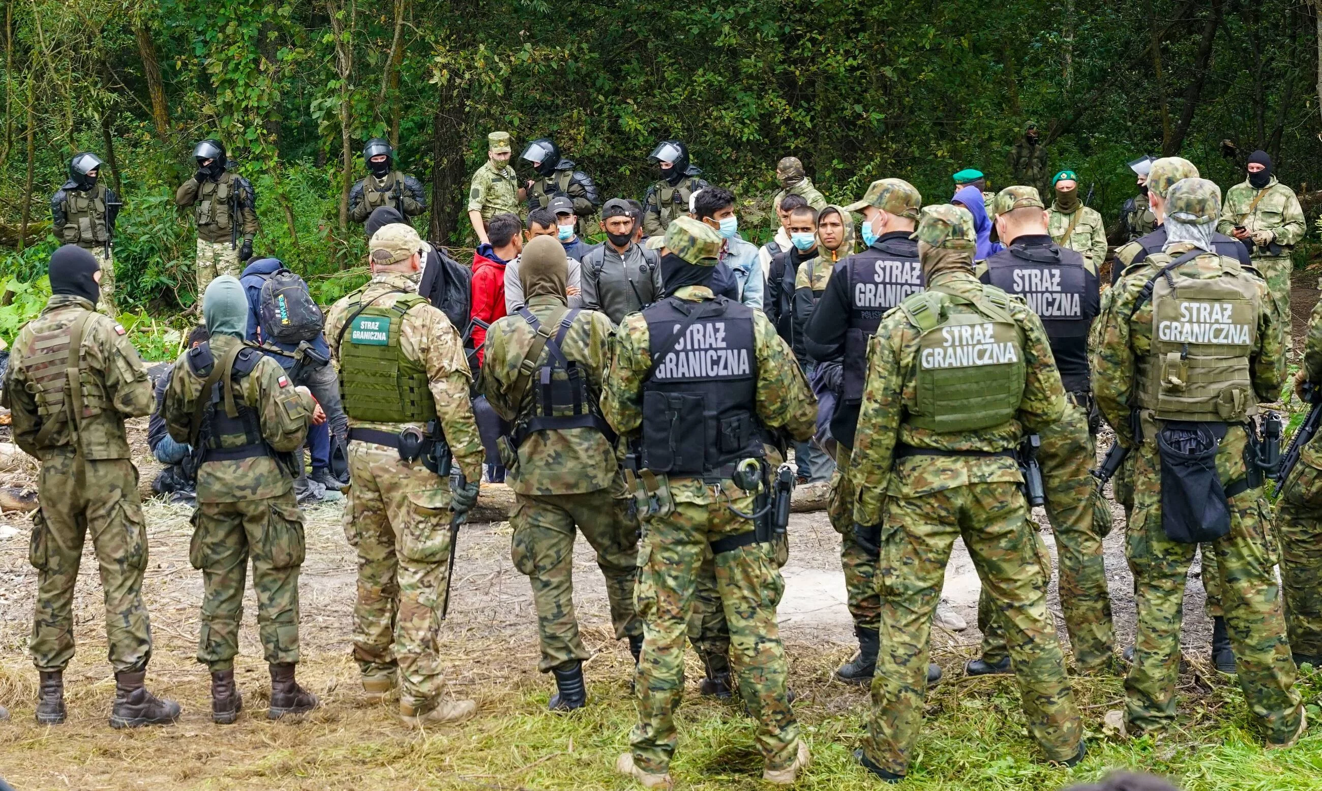 Migranci przebywający w Usnarzu Górnym oraz polska Straż Graniczna. Zdjęcie z sierpnia