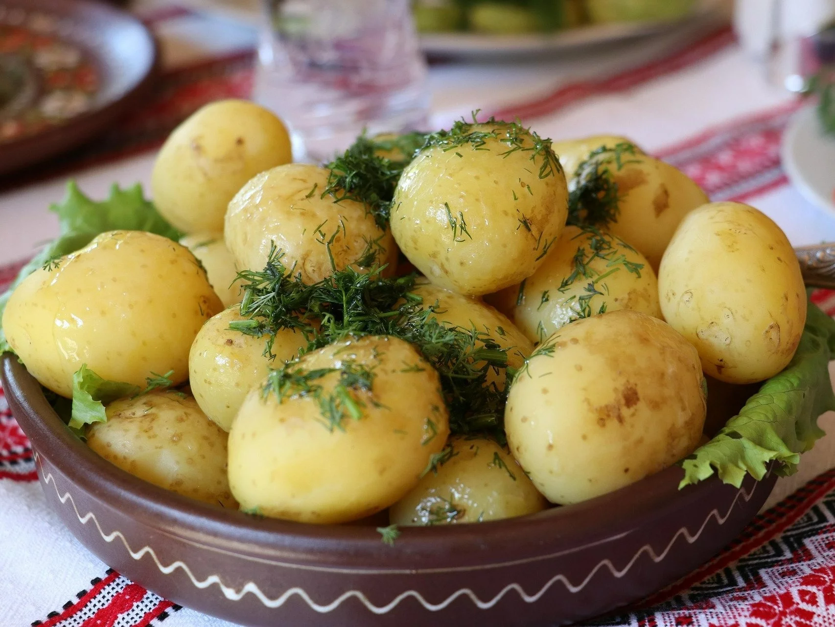 Młode ziemniaki z masłem i posypane koperkiem