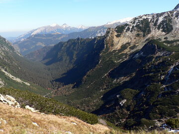 Widok doliny ze szlaku turystycznego na przełęcz Krzyżne. W tle Tatry Bielskie