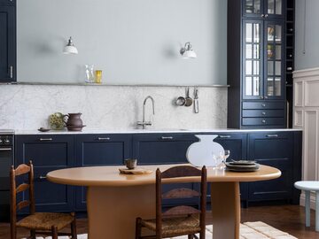 Wnętrze w stylu skandynawskiego spokoju – szafki kuchenne mają kolor głębokiego błękitu w matowym wykończeniu. Ściany pomalowano tym samym kolorem o kilka tonów jaśniejszym